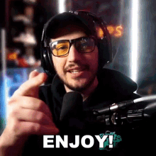 a man wearing headphones and glasses says enjoy in front of a microphone .