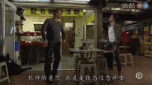 two men are standing in front of a store with chinese writing on it