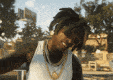 a man wearing sunglasses and a gold chain around his neck