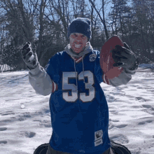 a man in a blue jersey with the number 53 on it is holding a football