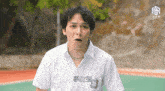 a man wearing a white shirt with chinese writing on the front