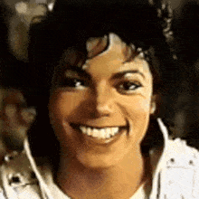 a close up of a person 's face with a white jacket on smiling .