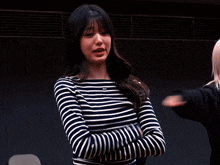 a woman wearing a striped shirt with a tommy hilfiger logo on it