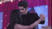 a man and a woman are holding hands while dancing