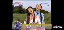 a man and a woman are laughing in front of a microphone with chinese writing on it