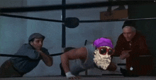 a man in a purple hat and sunglasses is in a boxing ring with two other men