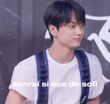a young man wearing a white shirt and blue suspenders is smiling with the words sonrei si sos de sofi written below him