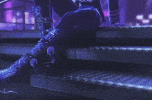 a person is sitting on a set of stairs with purple lights behind them