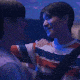 a couple of men are kissing each other in a room .