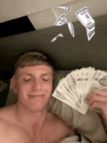 a shirtless man is holding a fan of money that says 20