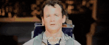 a man sitting in a chair with the words heat 'em up smokin ' on his face