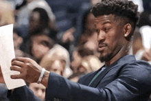 a man in a suit is holding a piece of paper