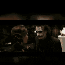 the joker is holding a knife and says come here i 'll put smile on your face