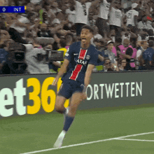 a soccer player wearing a qatar jersey celebrates on the field