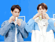 two men are drinking from a can that says ' tropicana '
