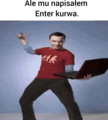 a man in a red shirt is holding a laptop and says enter kurwa