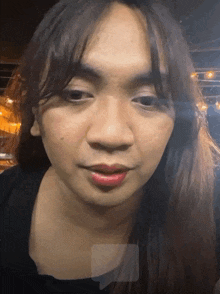 a close up of a woman 's face with a black shirt on