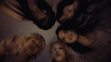 a group of women laying in a circle with their faces in the middle