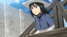 a girl wearing a white hat and a blue cape is standing on a wooden railing