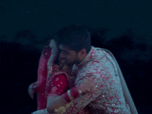 a man and a woman are hugging each other in a dark room