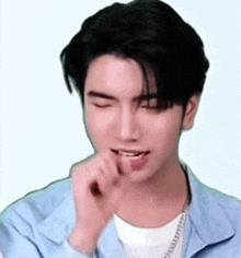 a young man with his eyes closed and his tongue sticking out .