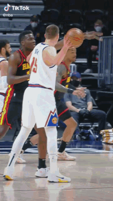 a basketball player with the number 15 on his jersey holds the ball