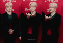 a man making a heart shape with his hands in front of a sign that says u + live