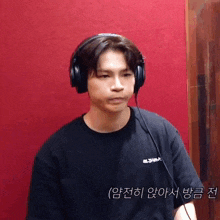 a man wearing headphones and a black t-shirt with chinese writing