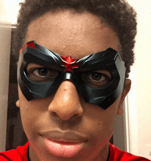 a young boy wearing a mask with a red star on it