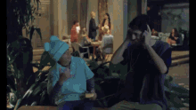 a man and a child are sitting on a bench talking