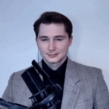 a man in a suit is holding a microphone in his hands