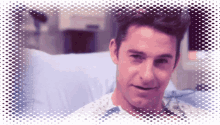 a man is sitting in a hospital bed smiling