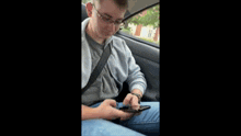 a young man is sitting in the back seat of a car holding a gun