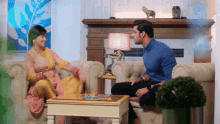 a man and a woman are sitting on a couch in a living room