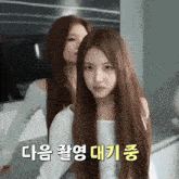 a woman with long hair is standing next to another woman with long hair