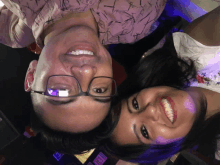a man and a woman are posing for a picture with the man wearing glasses and the woman smiling