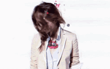 a woman with flowers in her hair covering her face .