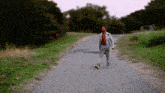 a man in a suit walks down a road with the letter f on the ground