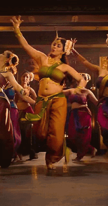 a woman in a green top is dancing in front of a group of other women