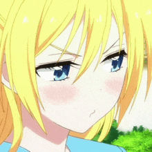 a close up of a girl with yellow hair and blue eyes making a funny face