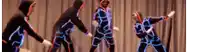 a group of people are dancing on a stage in neon costumes