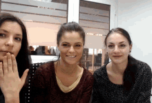three women are posing for a picture in front of a window that says ' sliding glass '