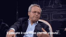 a man sitting in a chair with the words il passato è una cosa che hai vissuto above him