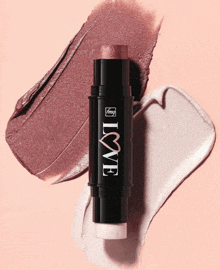 a stick with the word love on it next to a swatch of lipstick
