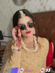 a woman wearing sunglasses is sitting on a couch next to a sign that says bhooo