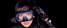 a man wearing a mask and goggles is holding a camera in his hand .