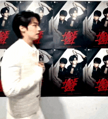 a man is standing in front of a wall with hide out posters on it