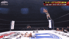 a female wrestler is jumping in the air while another wrestler is laying on the ground