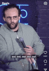 a man holding a microphone with the words oui oui oui oui on the screen