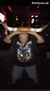 a man wearing a shirt that says capt.killer is holding a large horn